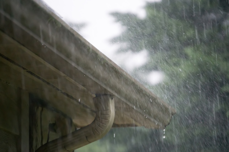 heavy rain falling on roof and gutter