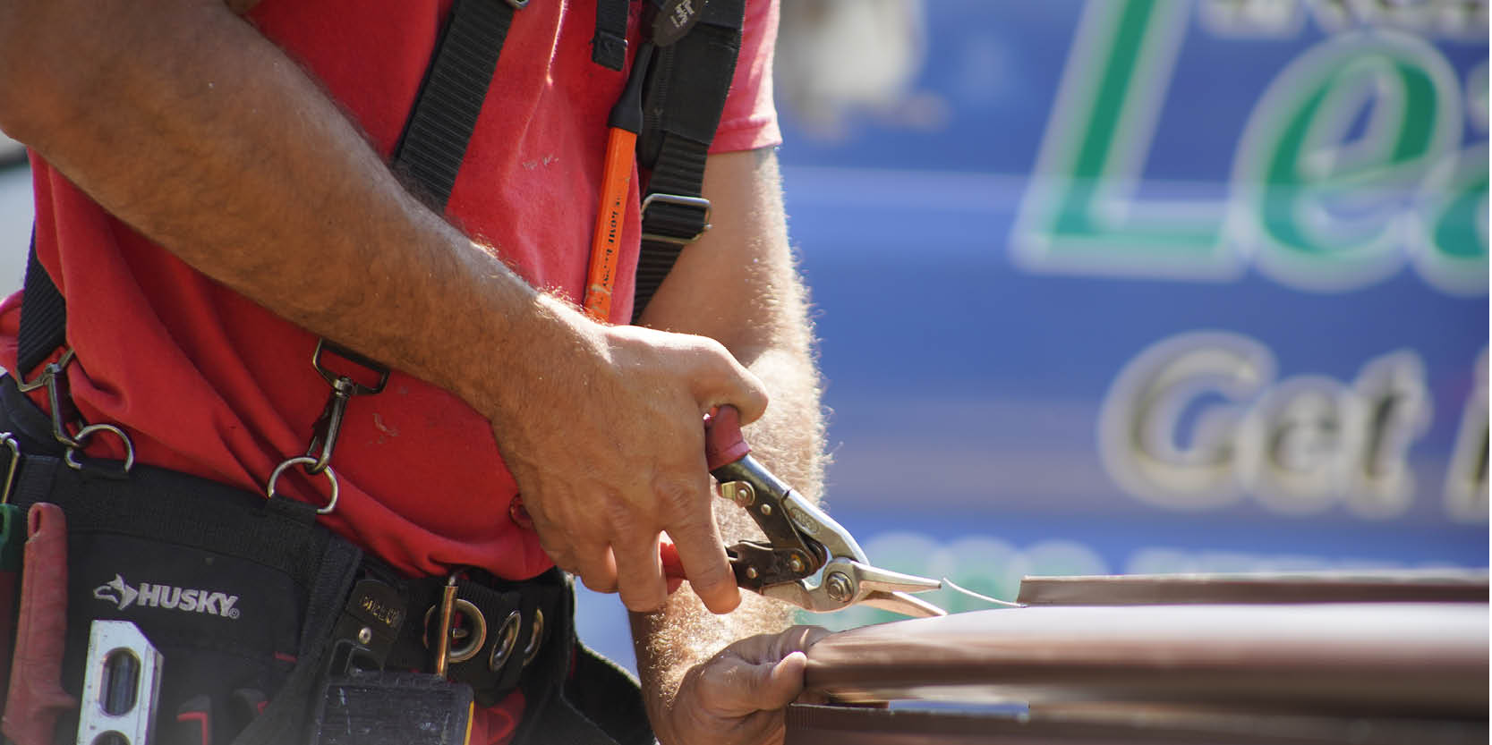 Installer cutting a gutter with snips