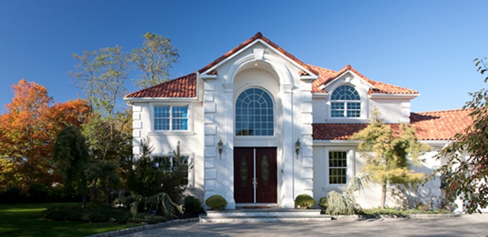 LeafGuard gutters shown on a stucco tile roof home